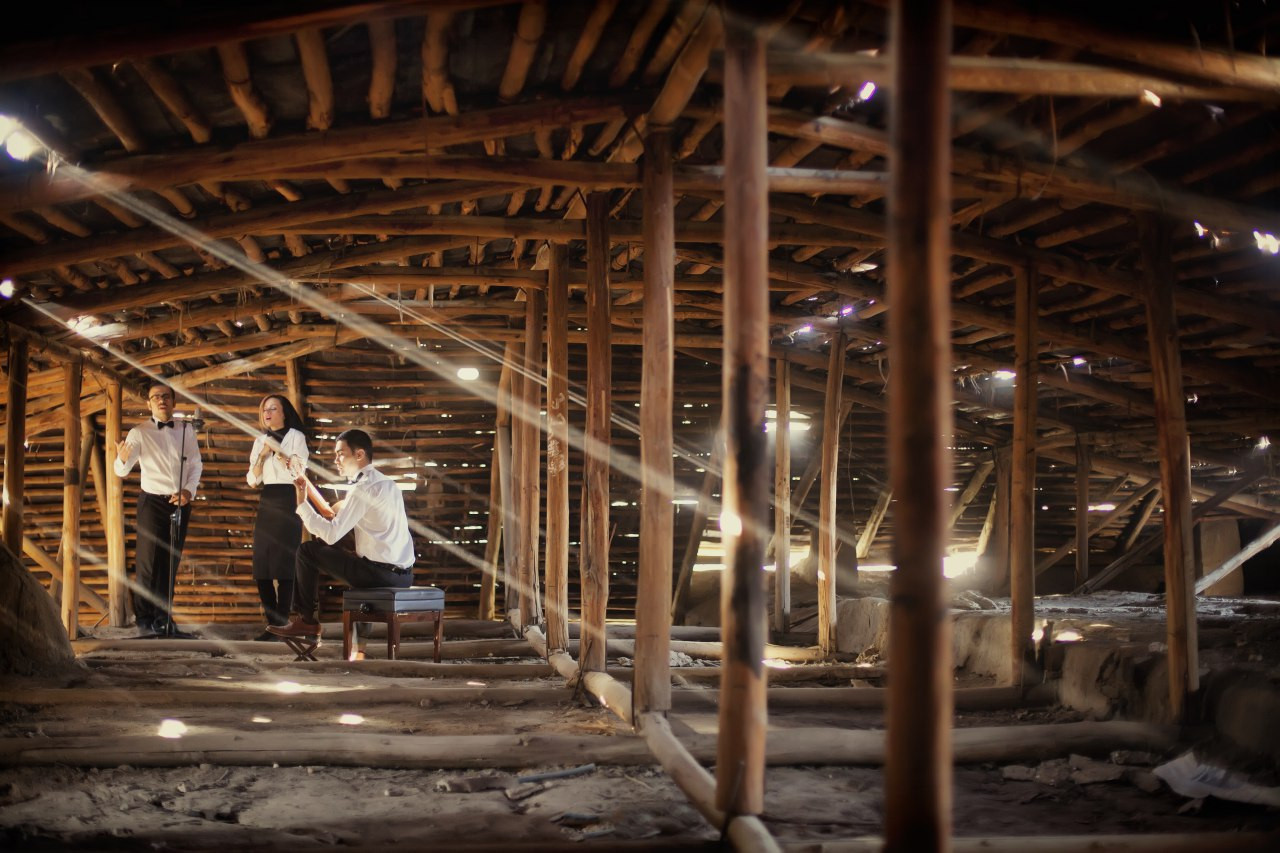 A wide view of three performers inside a wooden structure