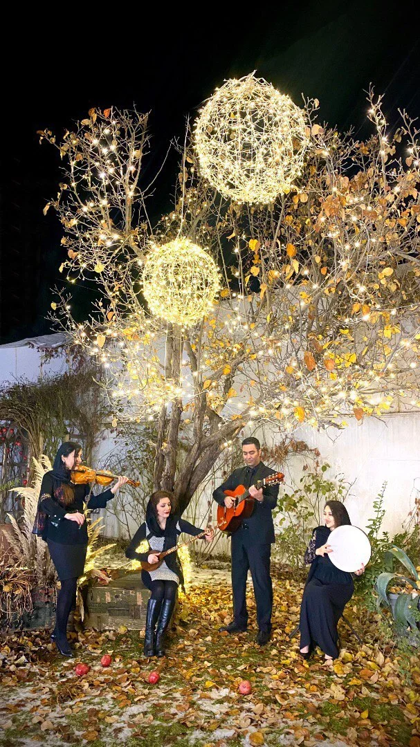 Hooniak performing beneath illuminated trees